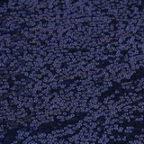 Close-up of navy blue fabric with scattered sequins.