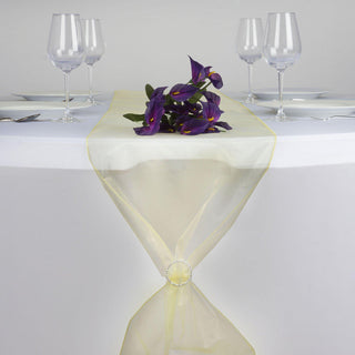 Yellow sheer table runner with floral accent on a dining table.
