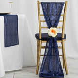 Gold chiavari chair adorned with a navy sequin sash and peach flower accent.