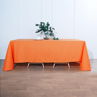 Add Elegance to Your Event with the 90"x132" Orange Seamless Polyester Rectangular Tablecloth