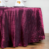 Burgundy tablecloth with a quilted texture draping over a table.