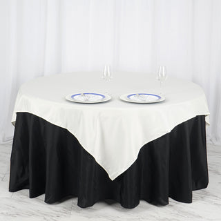 Add Elegance to Your Event with the 70x70 Ivory Square Seamless Polyester Table Overlay