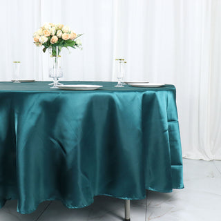Enhance Your Event Decor with the Peacock Teal 108" Seamless Satin Round Tablecloth
