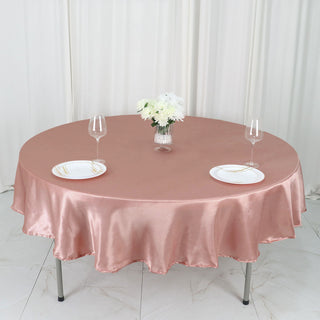 Add Elegance to Your Event with the 90" Dusty Rose Seamless Satin Round Tablecloth